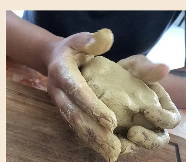 Mãos modelando argila em uma sessão de Arteterapia