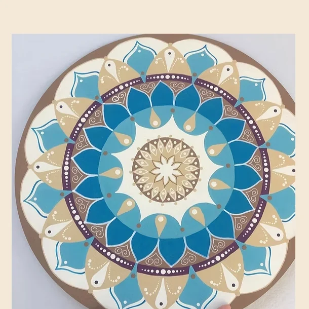 Mandala decorativa pintada em tons de azul, bege e vinho